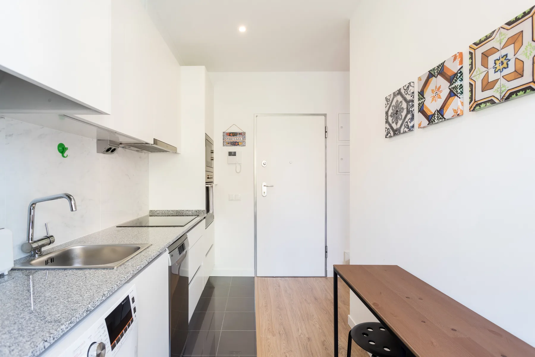 Una cocina compacta da a una zona de comedor con una mesa de madera.