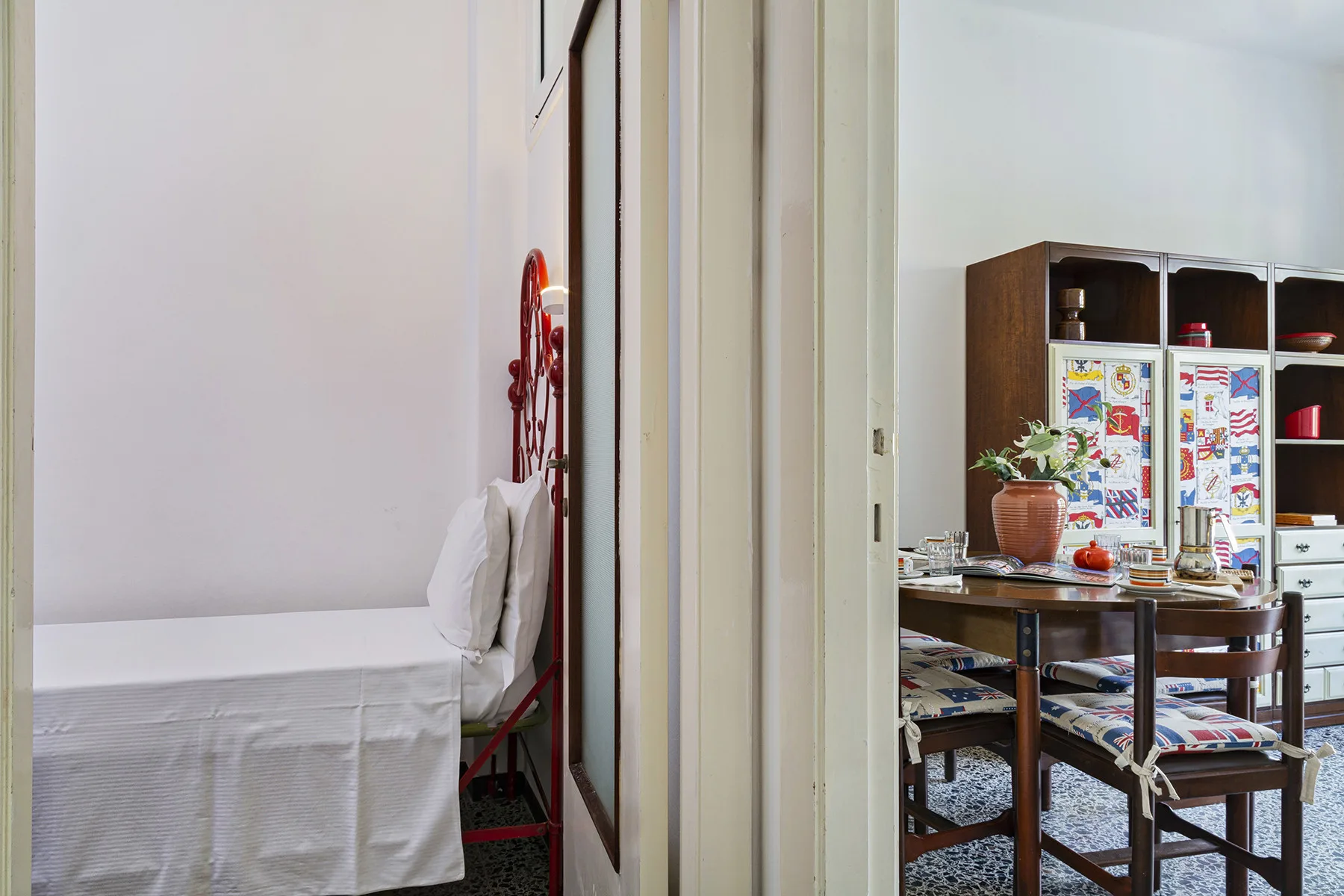 Un dormitorio con una cama junto a un comedor con mesa y sillas.