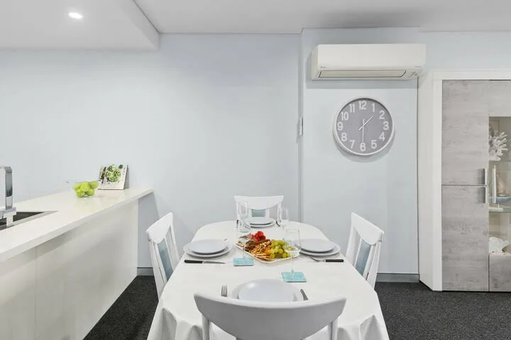 Un comedor con una mesa puesta junto a una encimera de cocina.