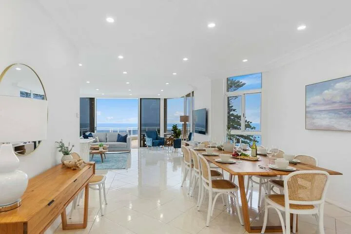 Un luminoso comedor y sala de estar se abre hacia grandes ventanas con vista al agua.