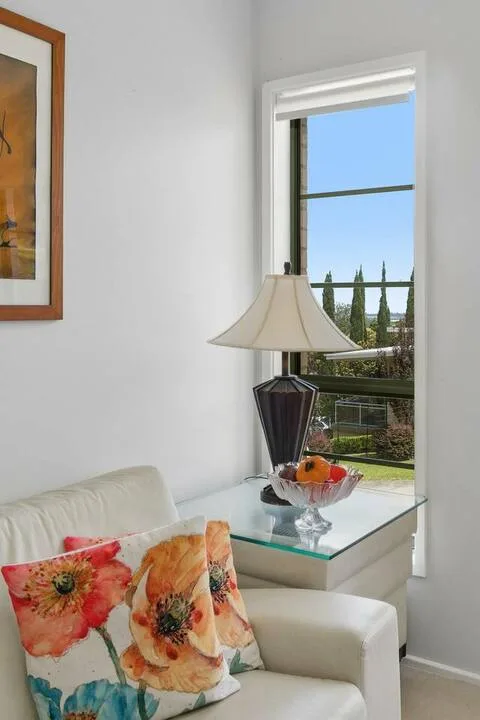 Una sala luminosa con asientos blancos junto a una ventana grande.