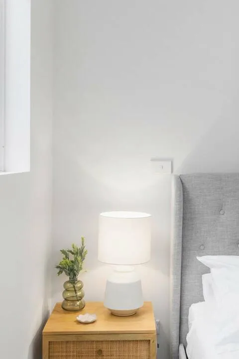 Un dormitorio con una lámpara de noche encendida junto a la cama.