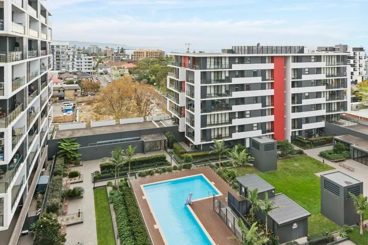 Un complejo de apartamentos ajardinado con una piscina y edificios residenciales modernos.