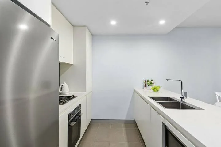 Una cocina moderna con una encimera larga y un fregadero.