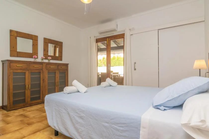 Un dormitorio con una cama grande y muebles de madera junto a la pared.