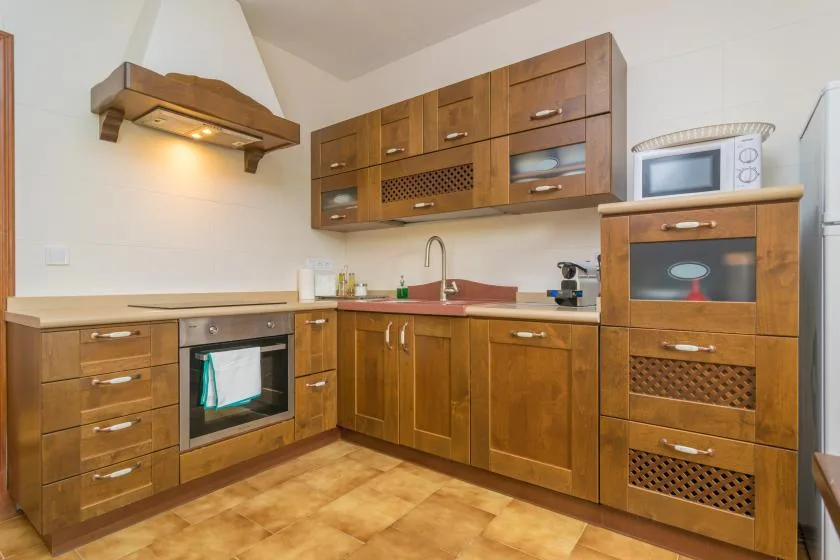 Una cocina equipada con armarios de madera, fregadero y electrodomésticos integrados.