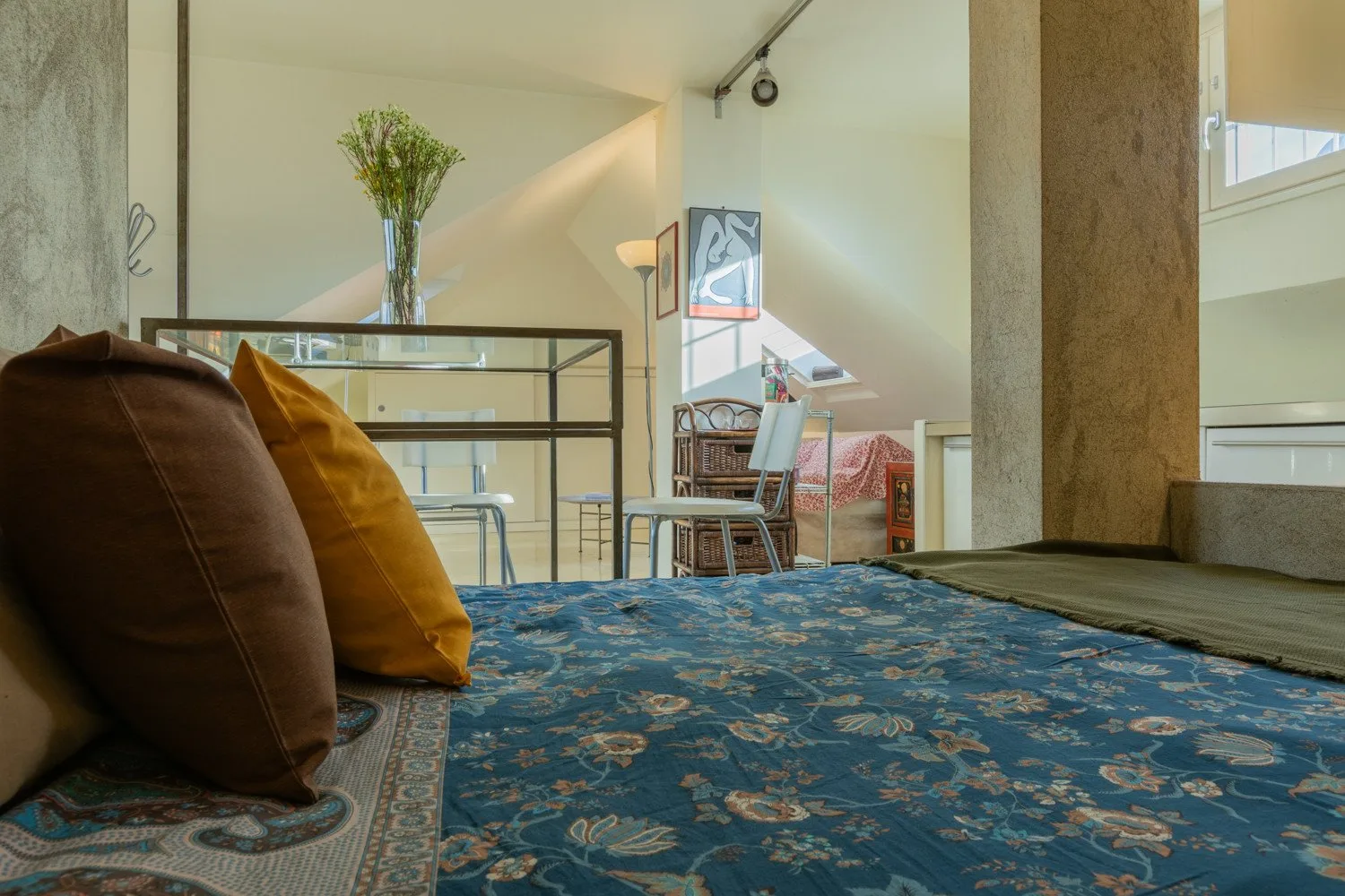 Una zona de estar con alfombras estampadas y una mesa detrás del asiento.