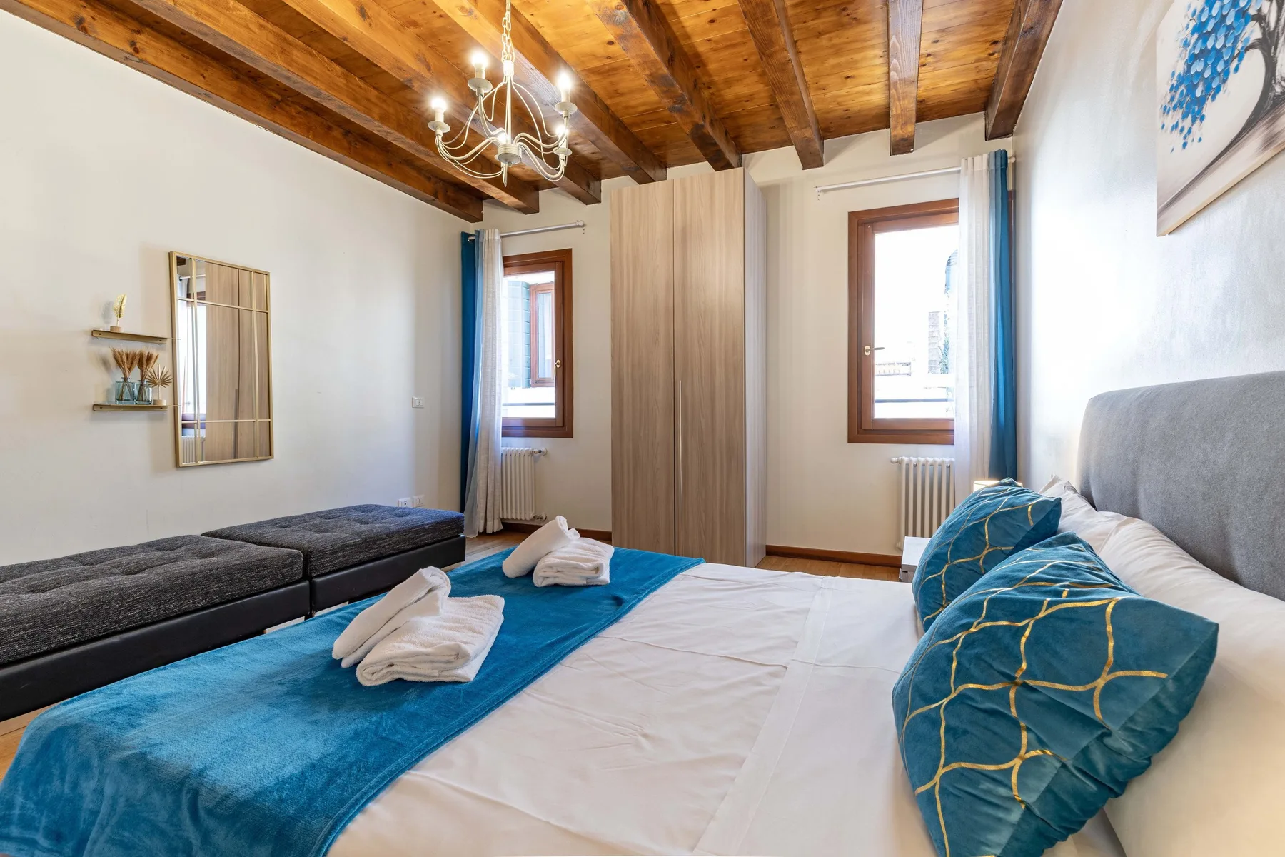 Un dormitorio con una cama vestida con ropa de cama blanca y azul.