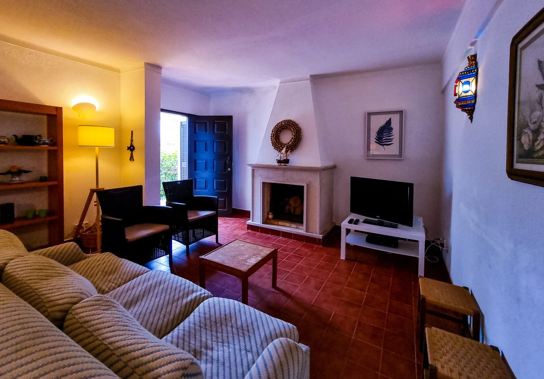 A living room with seating, a fireplace, and a television.