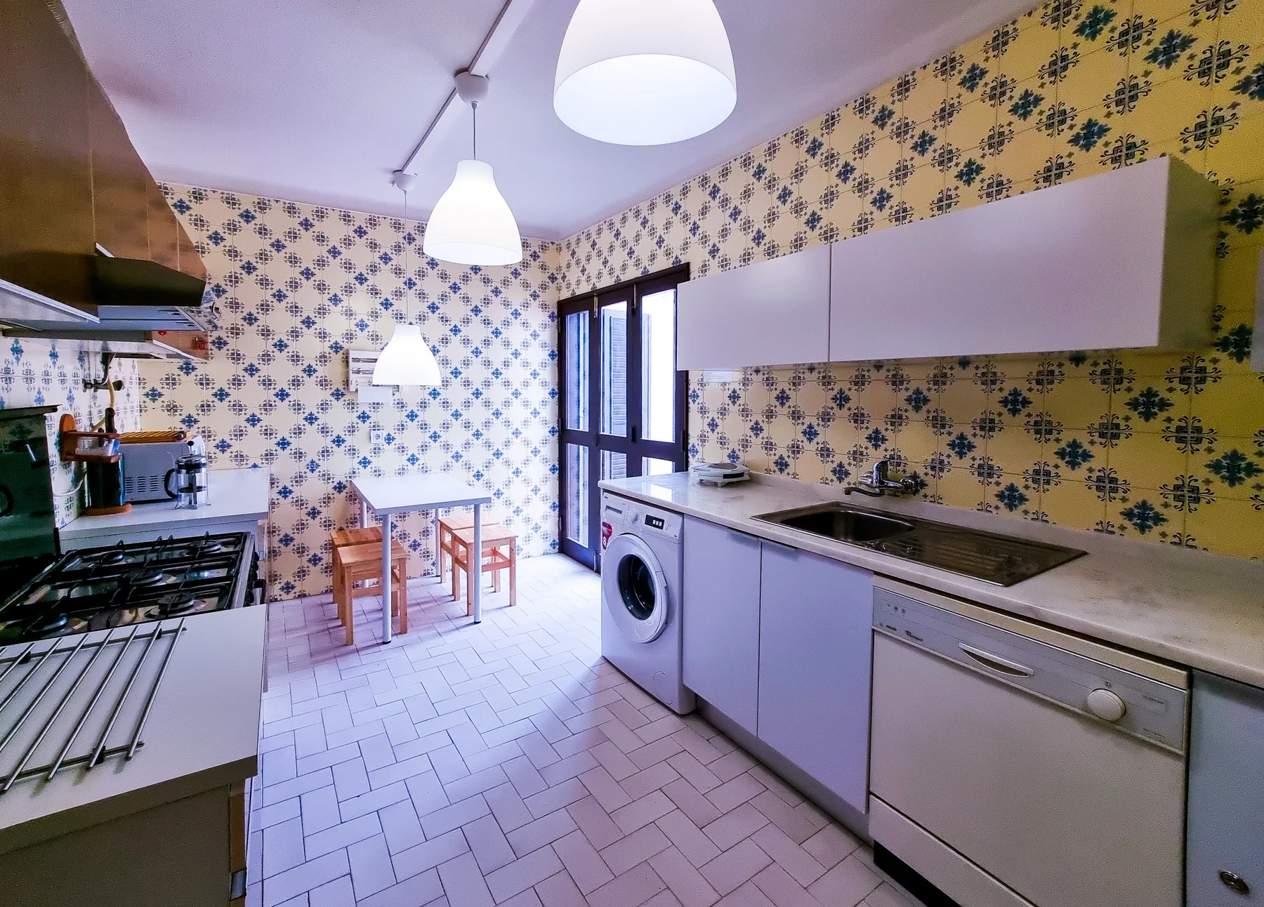 Una cocina luminosa con una mesa de comedor junto a las puertas de vidrio.