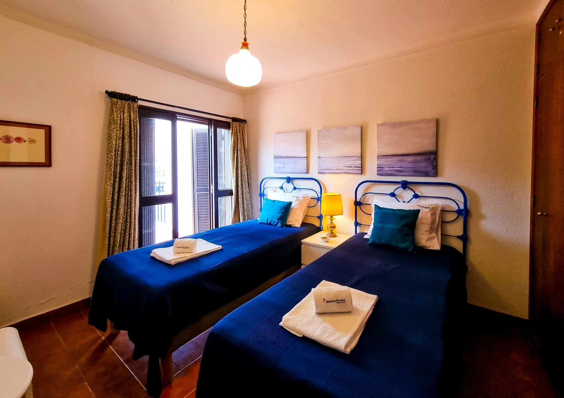 Un dormitorio con dos camas y una ventana que da a un balcón.