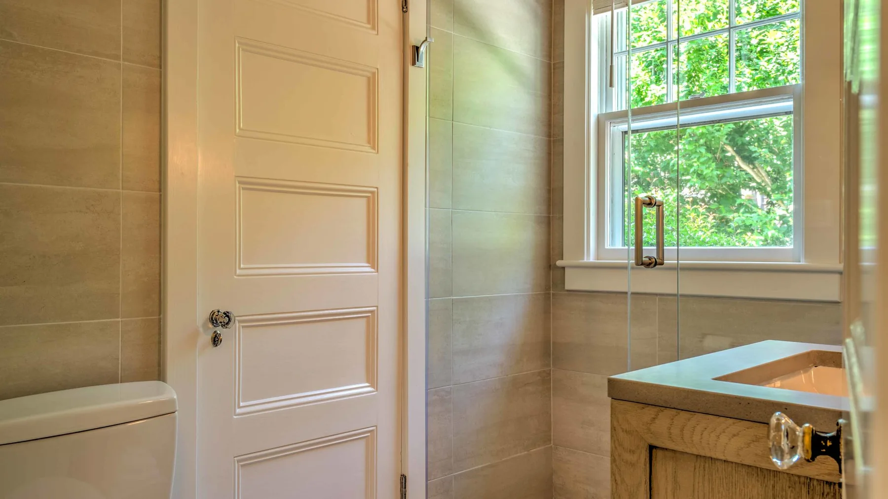 Un baño con una bañera junto a una ventana con vistas a la vegetación.