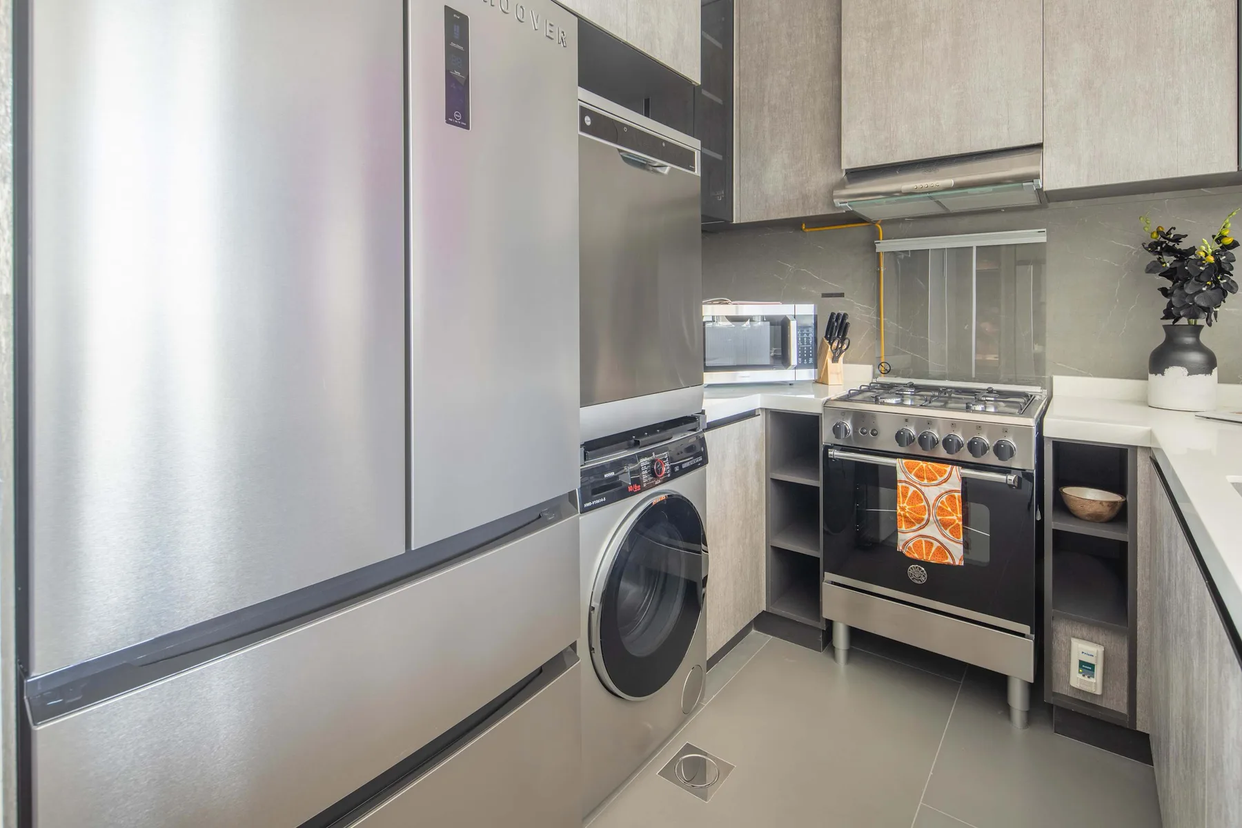 Una cocina moderna con electrodomésticos de acero inoxidable y gabinetes claros.
