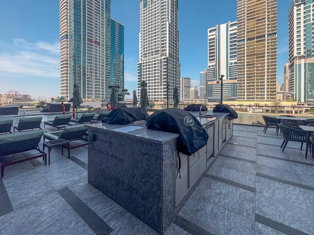 Una terraza en la azotea con asientos al aire libre y altos edificios al fondo.