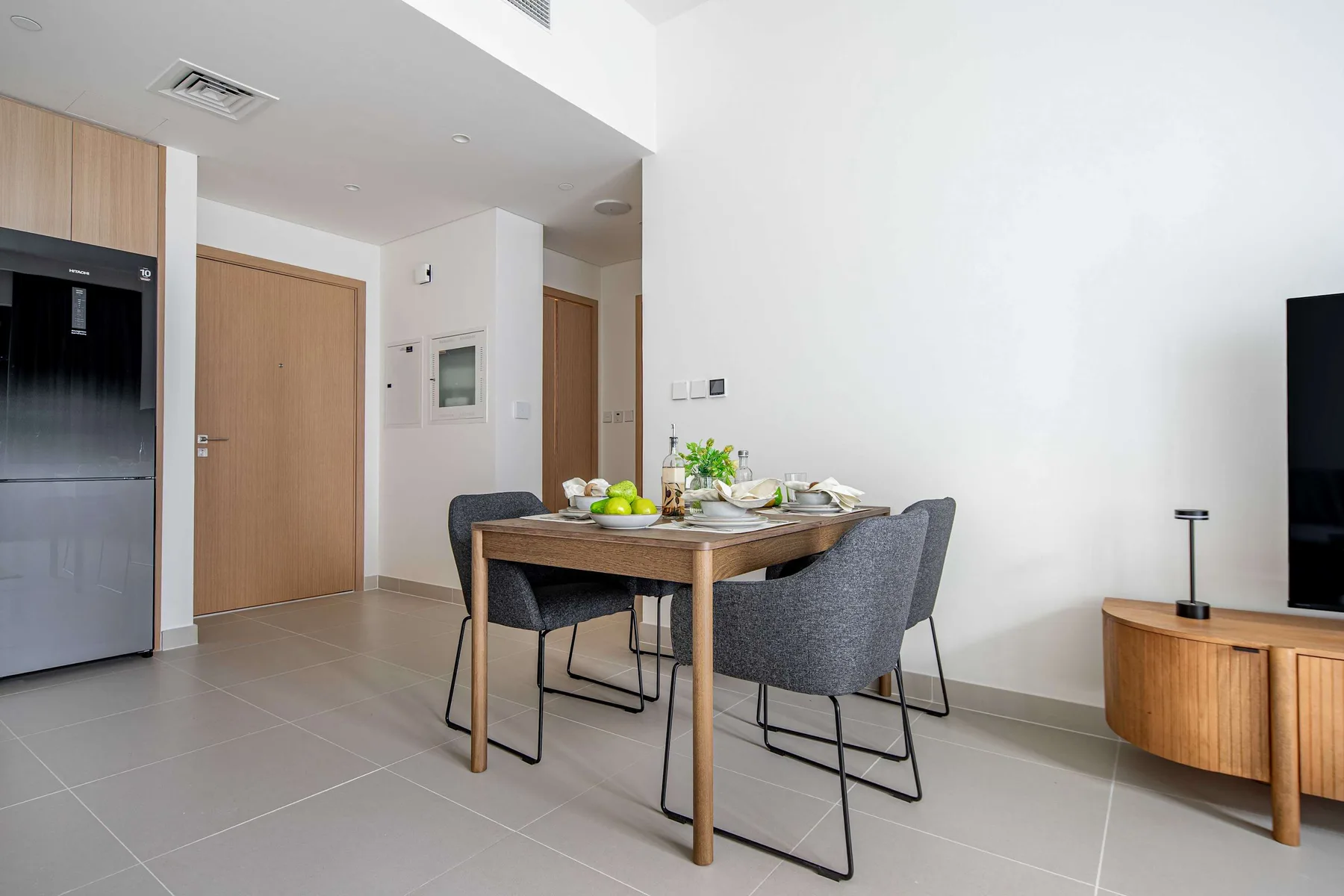 A dining area with a wooden table and gray upholstered seating.