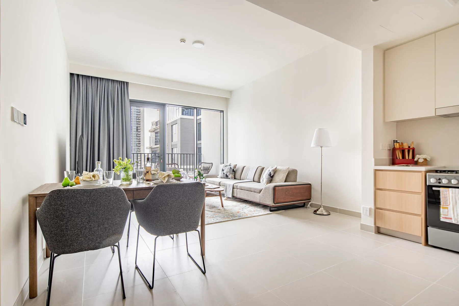 Una luminosa sala-comedor da a un balcón, con una cocina compacta a un lado.