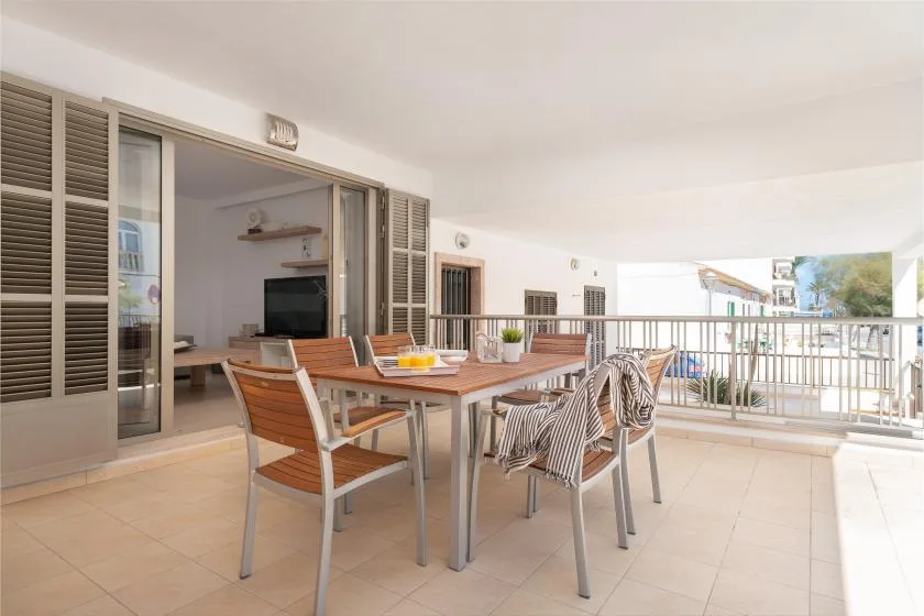 A covered terrace dining area with a table and seating beside the railing.