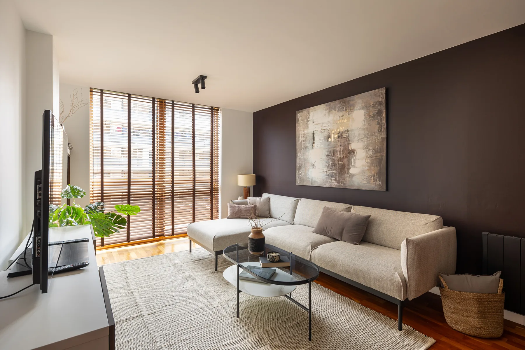 Una sala luminosa con asientos seccionales, una mesa de centro y ventanales.