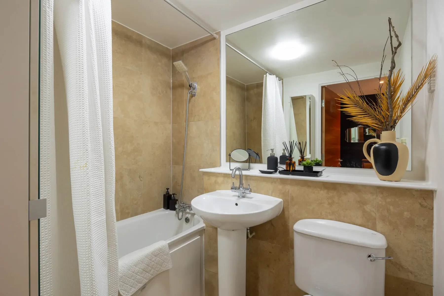 Un baño con bañera, lavabo y espejo.