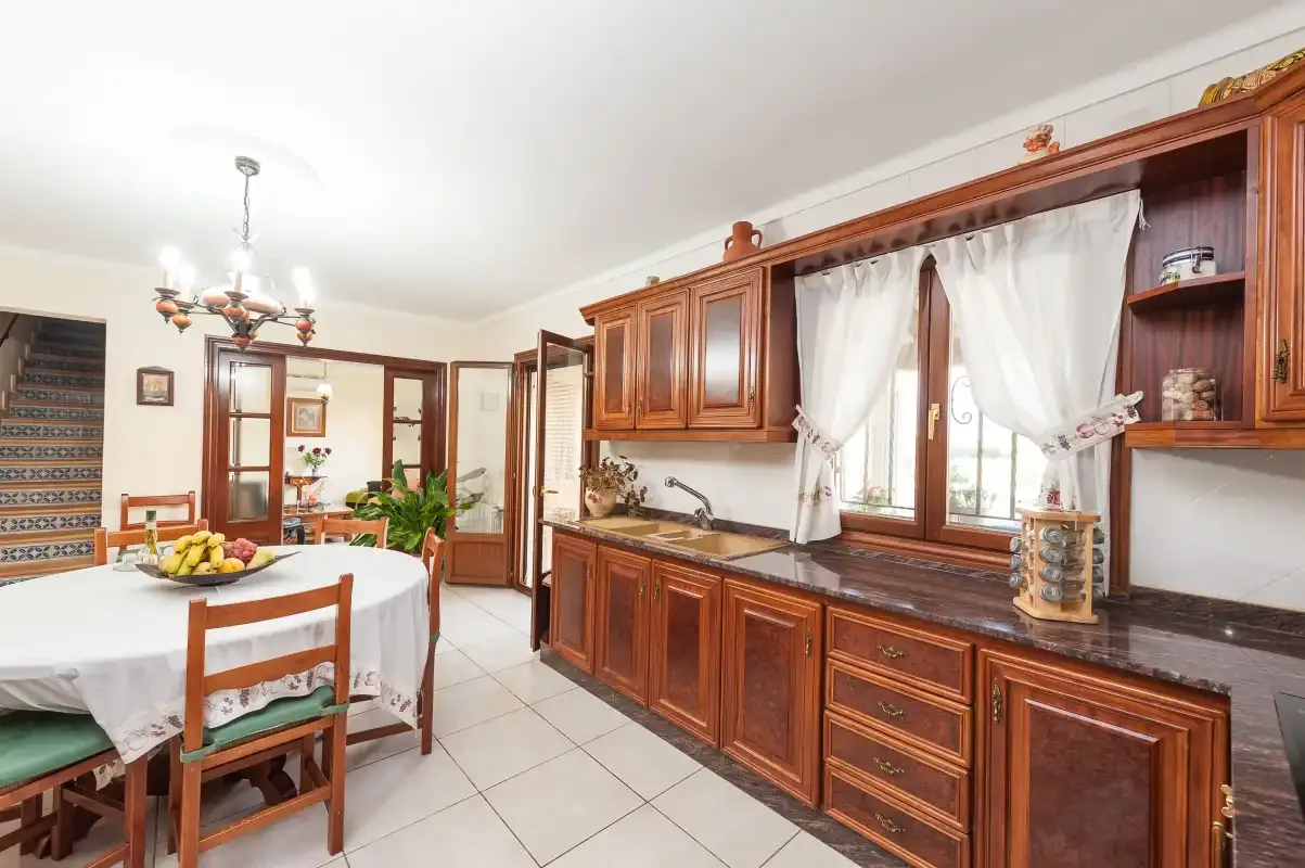 A kitchen and dining area with wooden cabinets and a table.