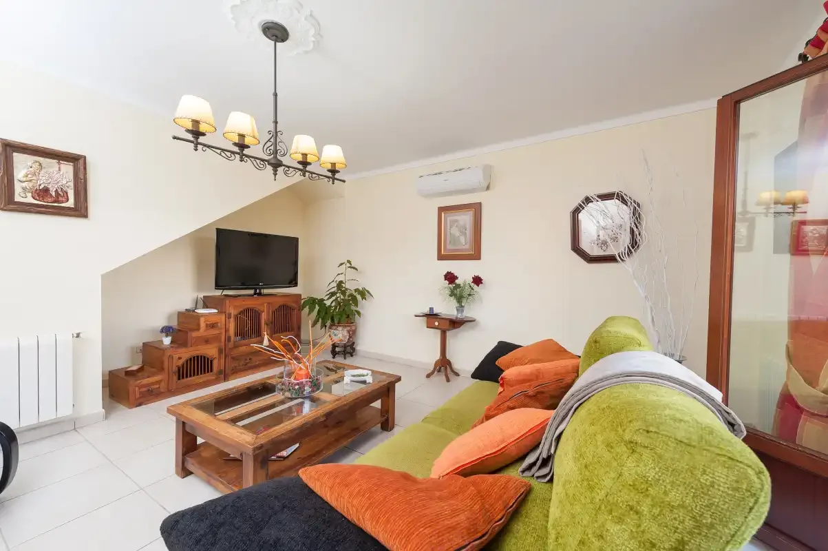 A living room with seating, a television, and a wooden coffee table.