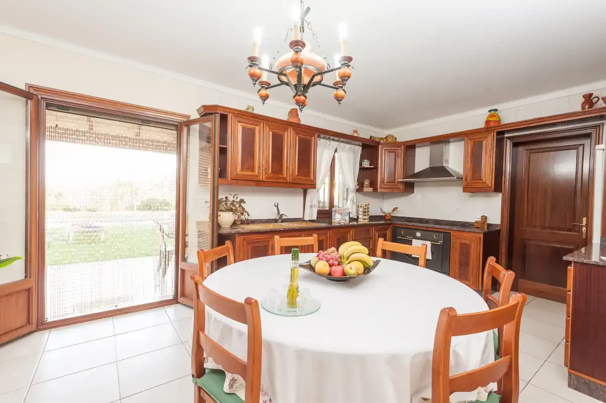 A kitchen and dining area with wooden cabinets and a large table.