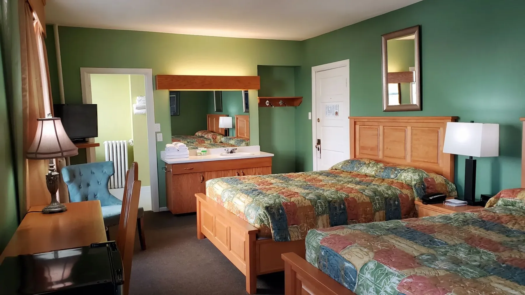 Una habitación de hotel con dos camas y un espejo