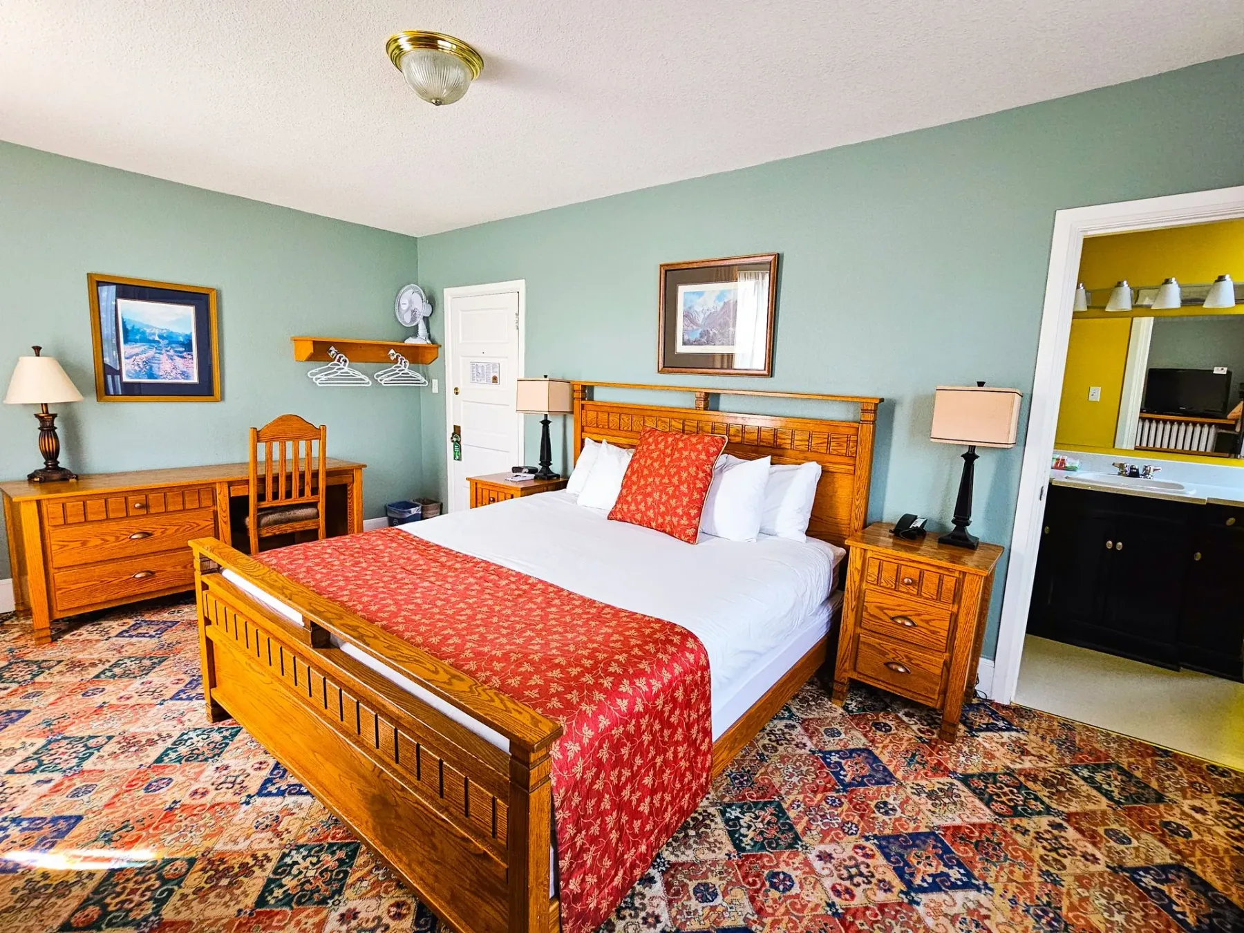 Una habitación de hotel con una cama king size y un escritorio