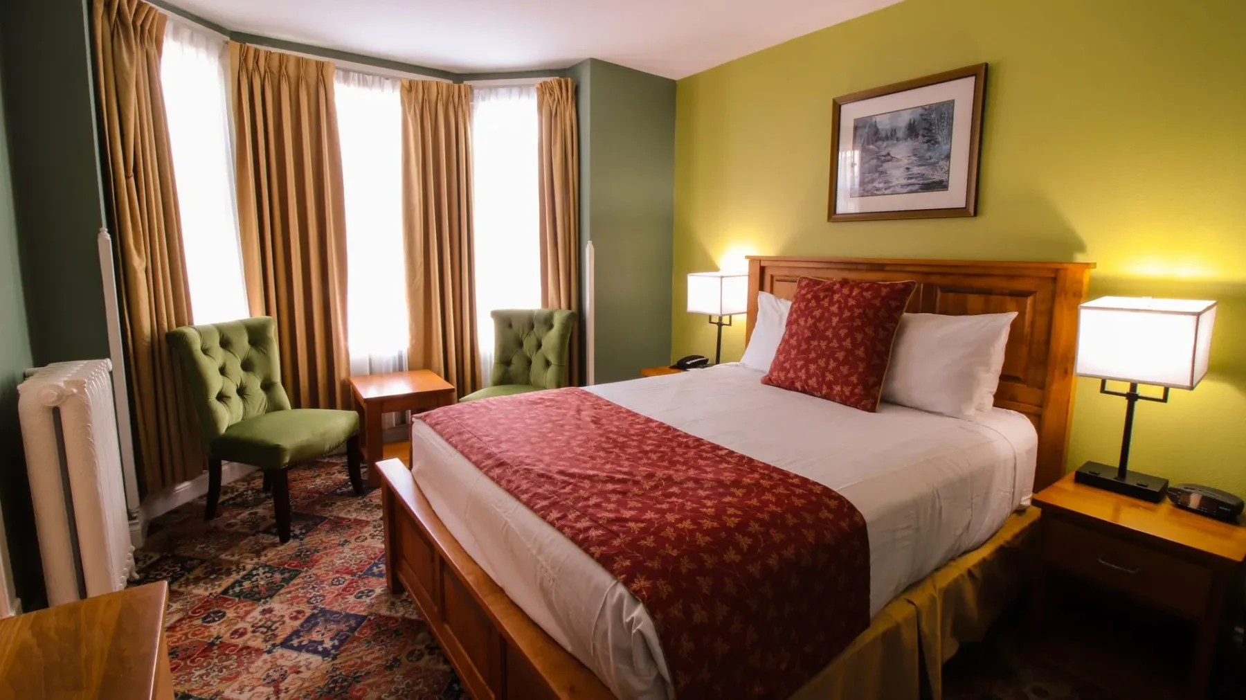 Una habitación de hotel con una cama king size y sillas verdes