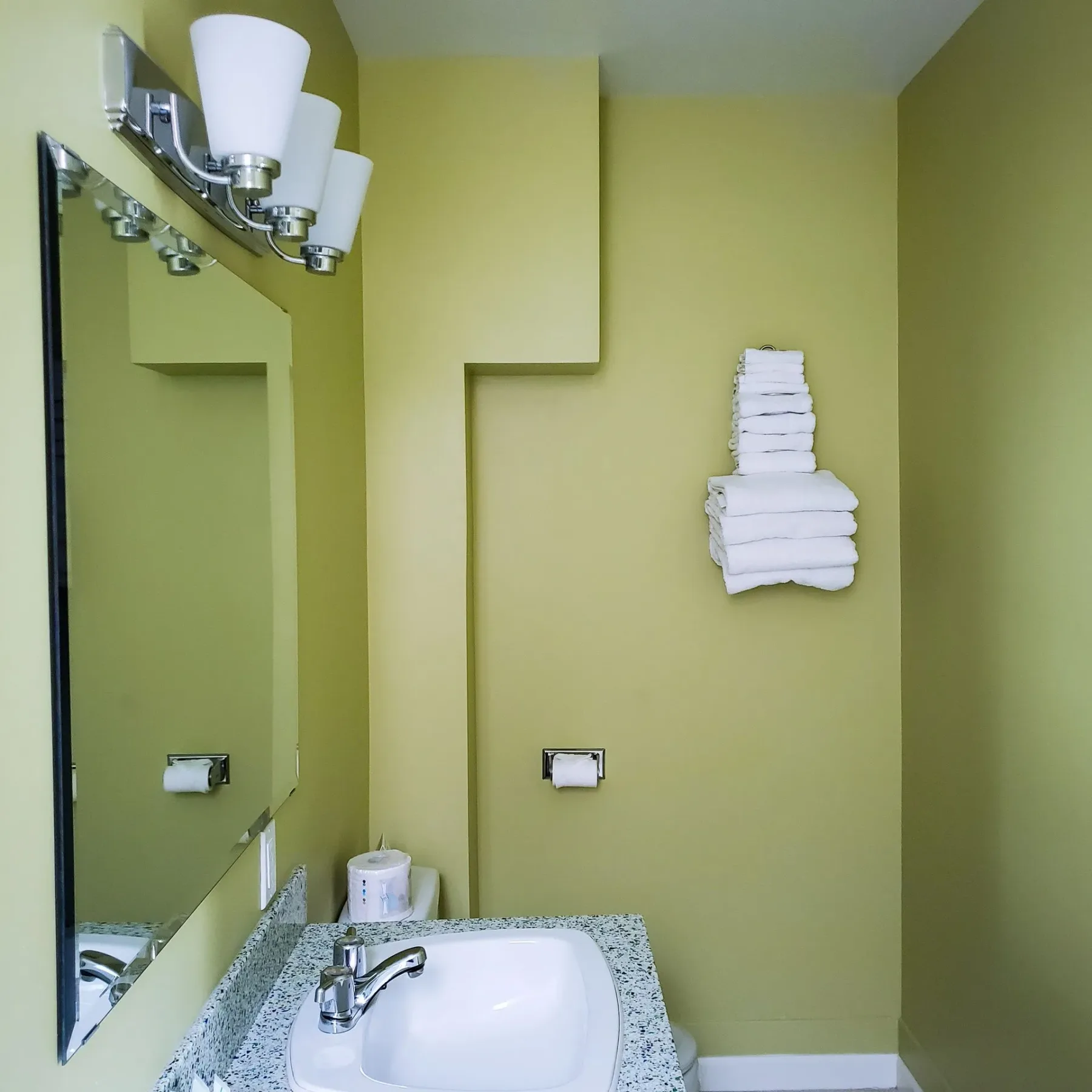 Un baño con un lavabo, un espejo y toallas