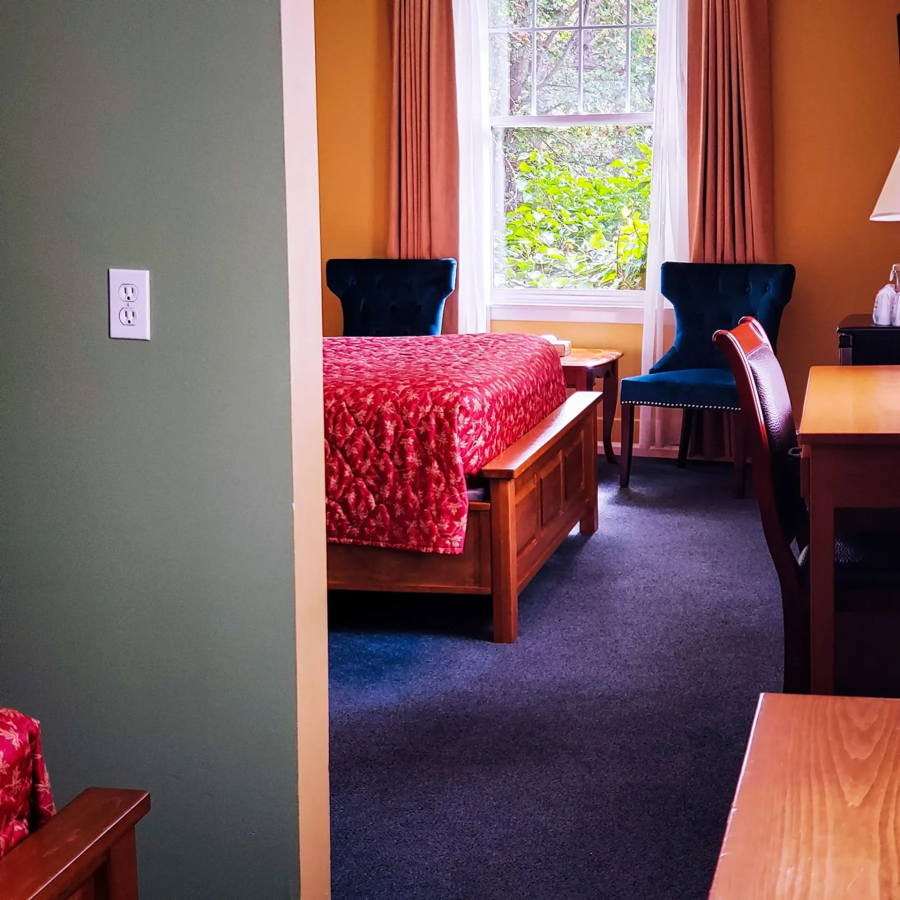 Una habitación de hotel con una cama, un escritorio y sillas