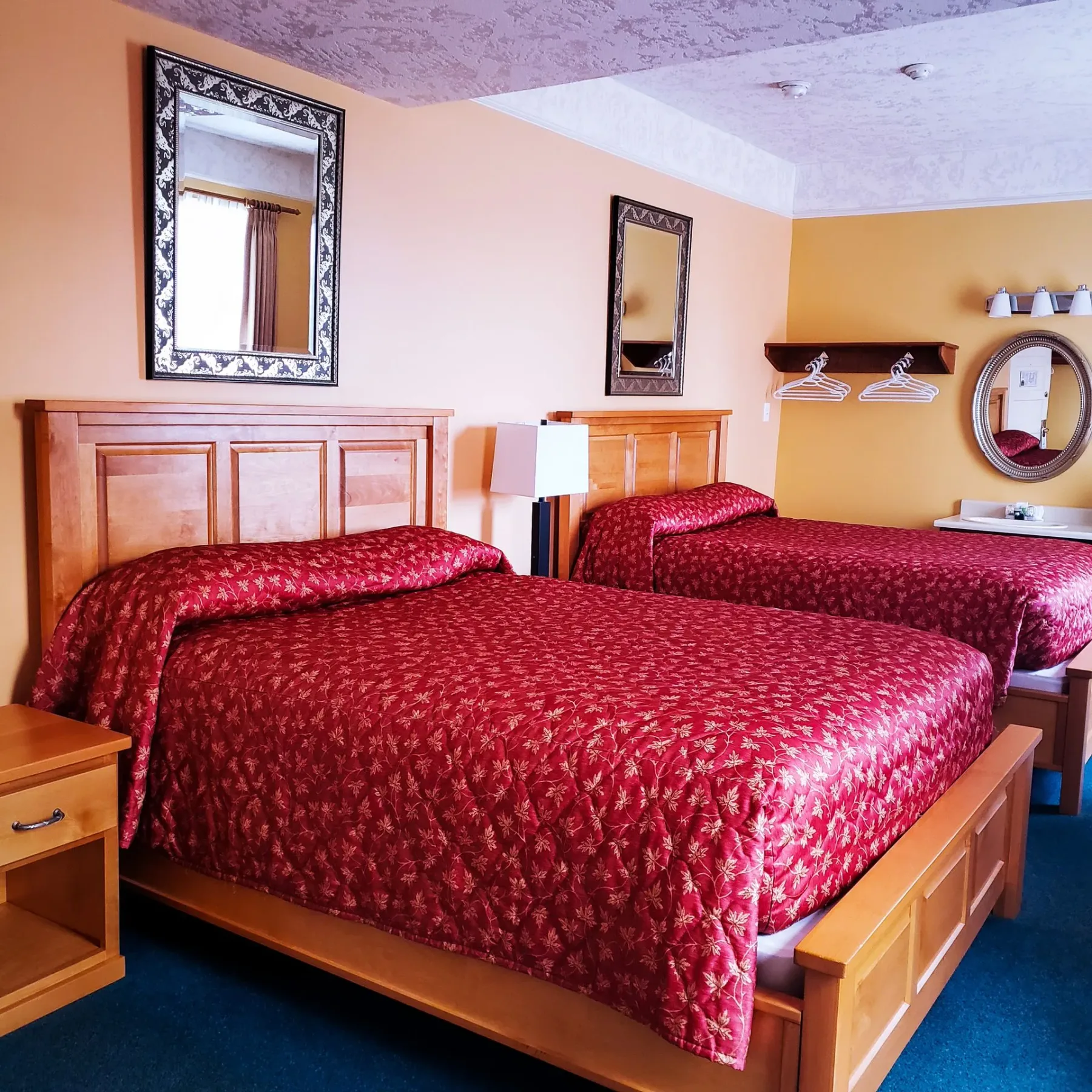 Una habitación de hotel con dos camas y dos espejos