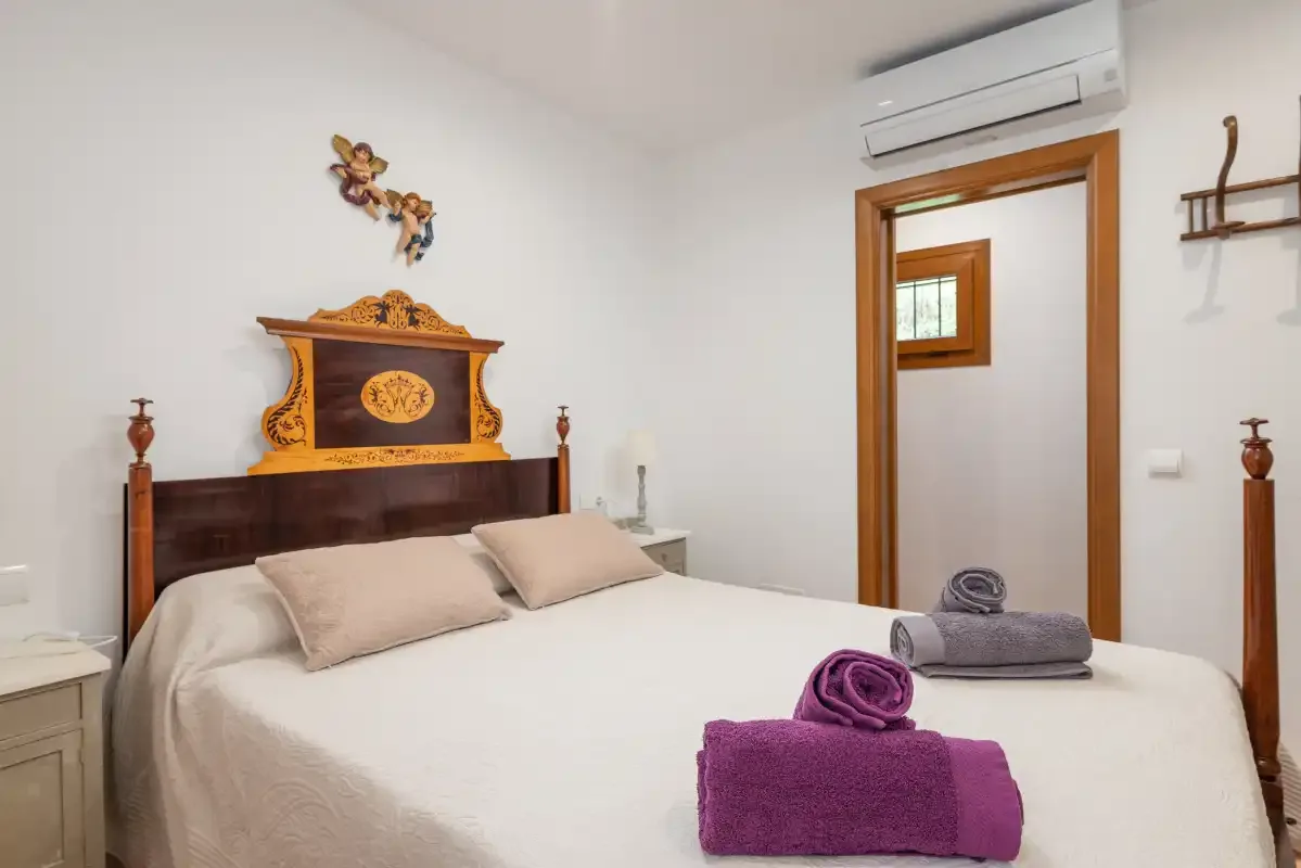 Un dormitorio con una cama bien tendida y toallas dobladas.