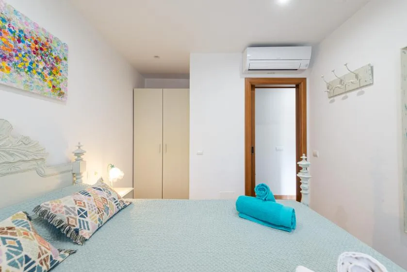 Un dormitorio luminoso con una cama, un armario y una puerta.