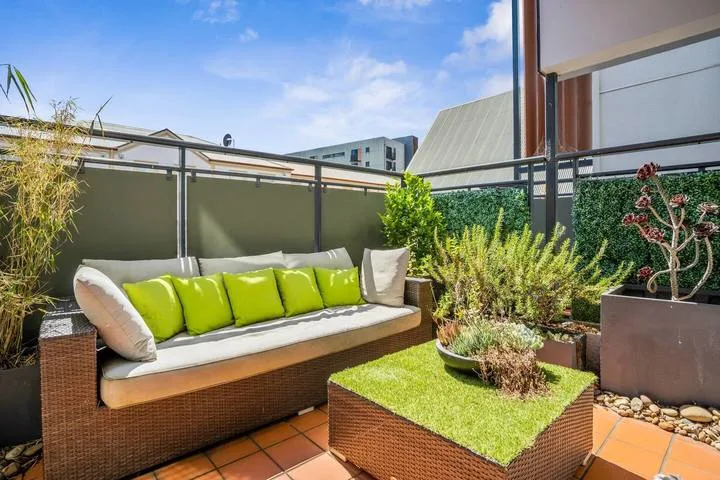A rooftop terrace with outdoor seating and a small green-topped table.