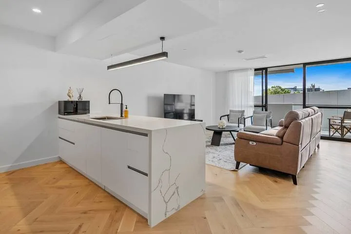An open-plan kitchen and living area with a large island and seating.