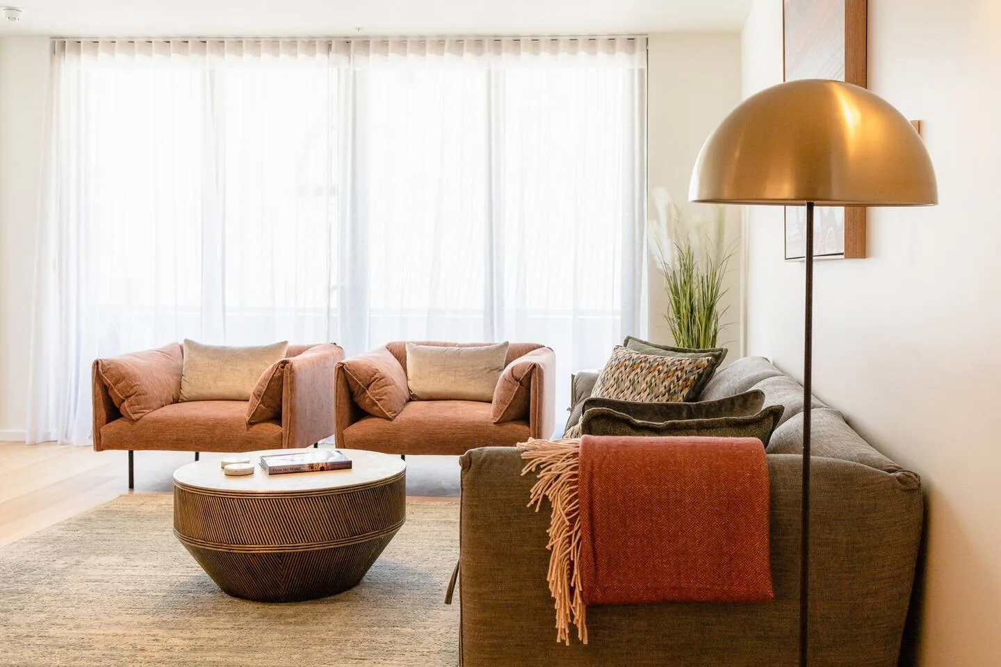 Sheer curtains filter light in the living area, creating a moody zone for a light read or cosy movie at home.