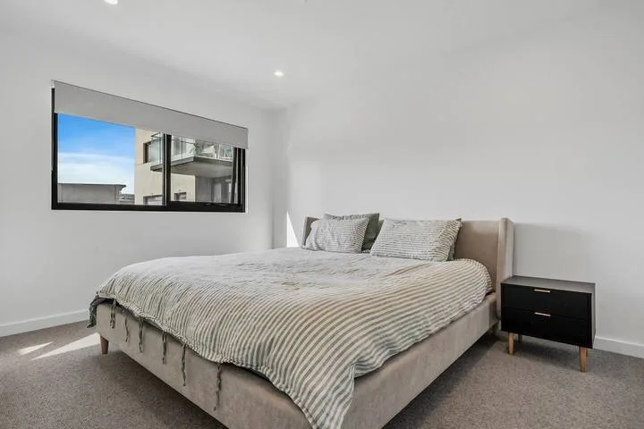 A bedroom with a large bed beneath a window.