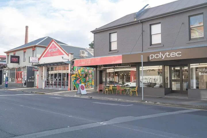 A street scene with neighboring storefronts and outdoor seating.