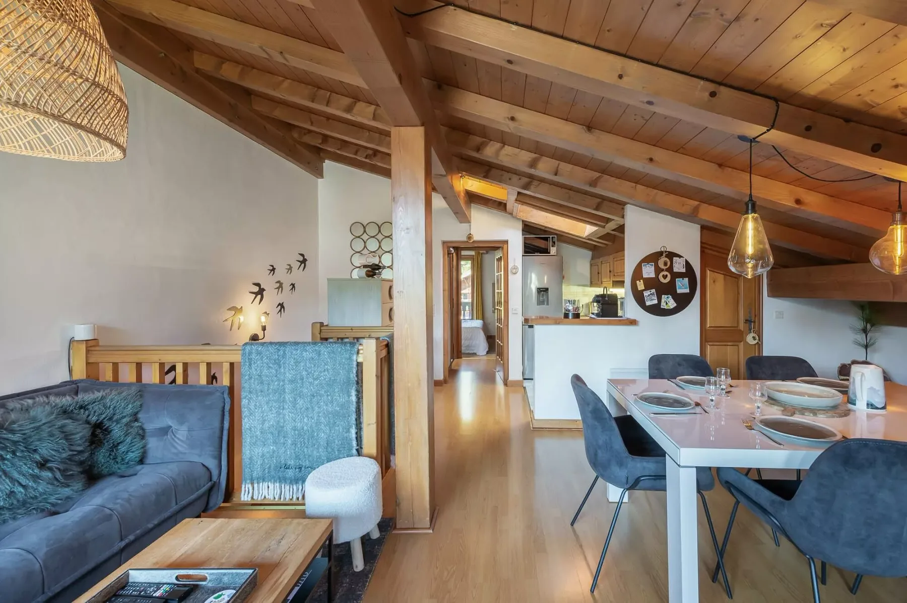 A wood-beamed living and dining area with a table and seating.