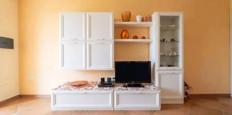 A living room with a television set into a built-in wall unit.