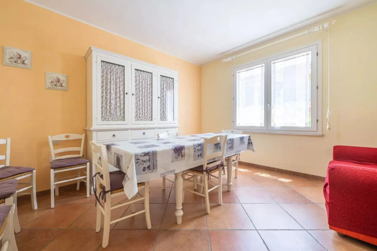 Un comedor con una mesa, sillas y una ventana grande.