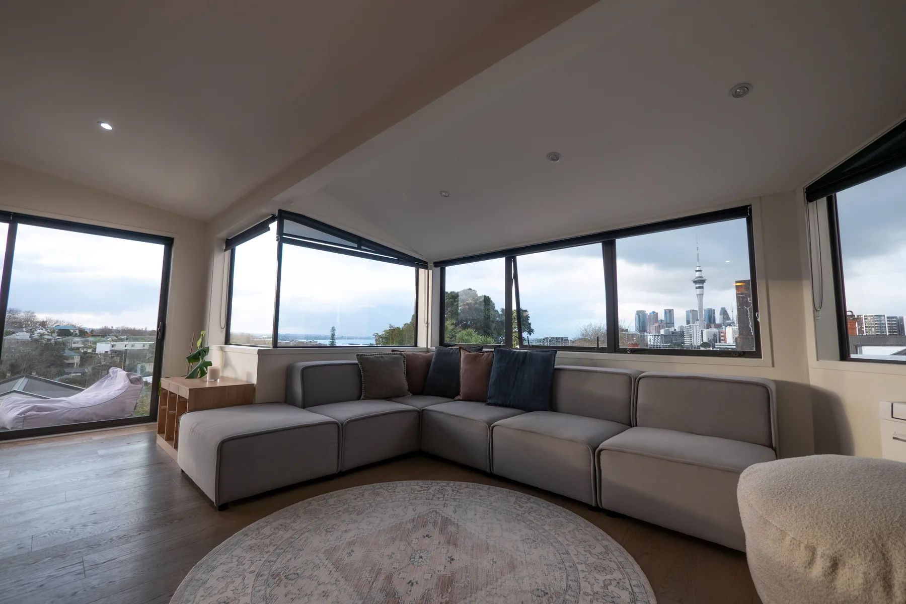 Una sala luminosa con asientos seccionales y grandes ventanas con vistas a la ciudad.