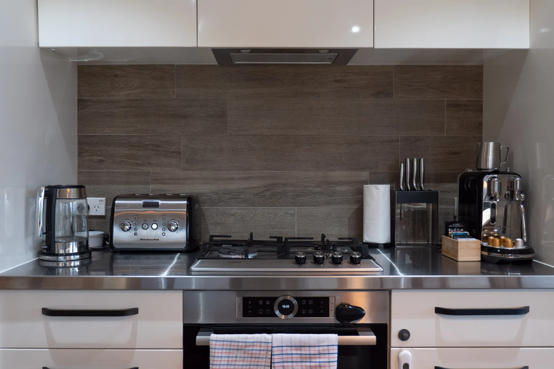 Una cocina moderna con una estufa y electrodomésticos sobre la encimera.
