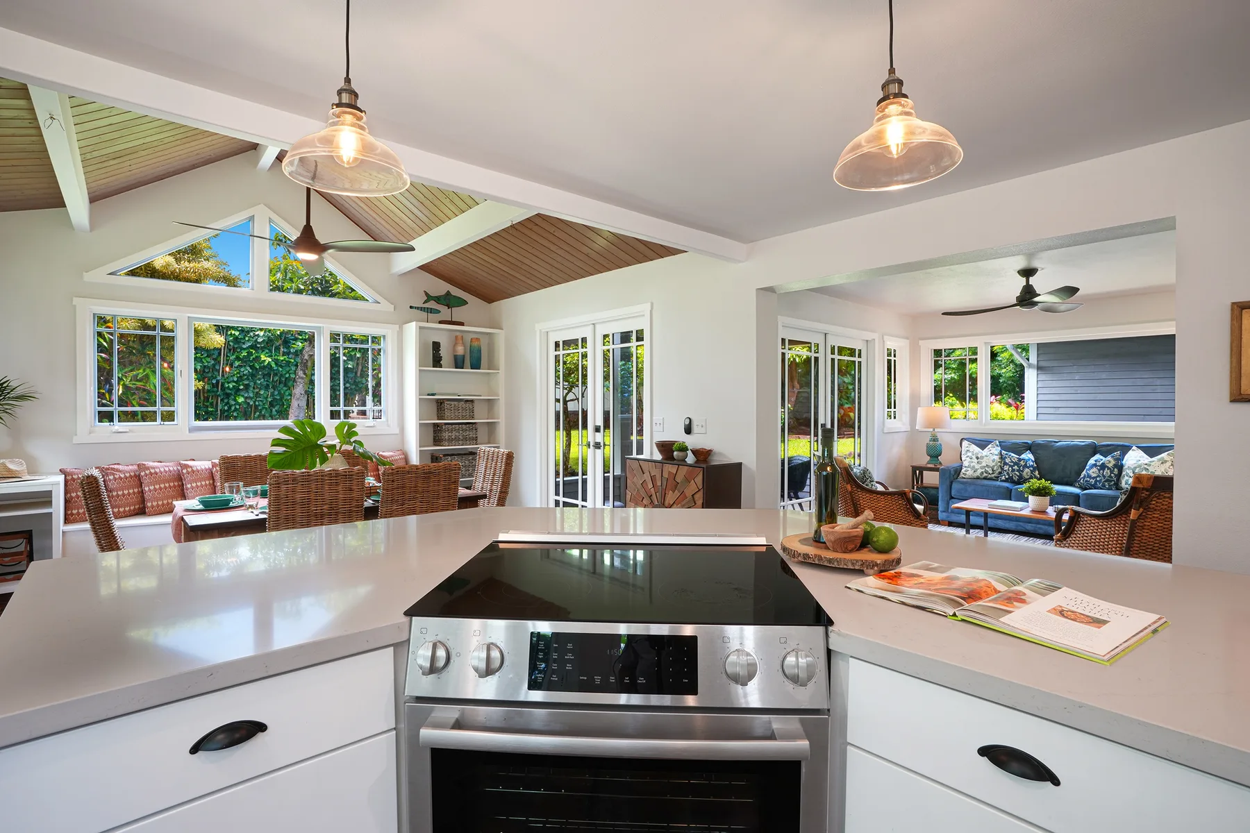 A bright open-plan kitchen and living area with a large island and windows.