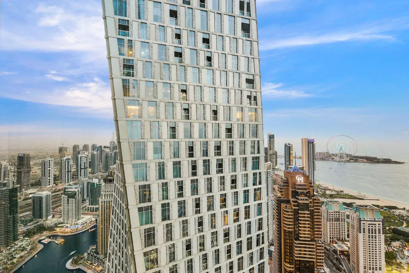 Una torre de gran altura domina el perfil urbano y el paseo marítimo.