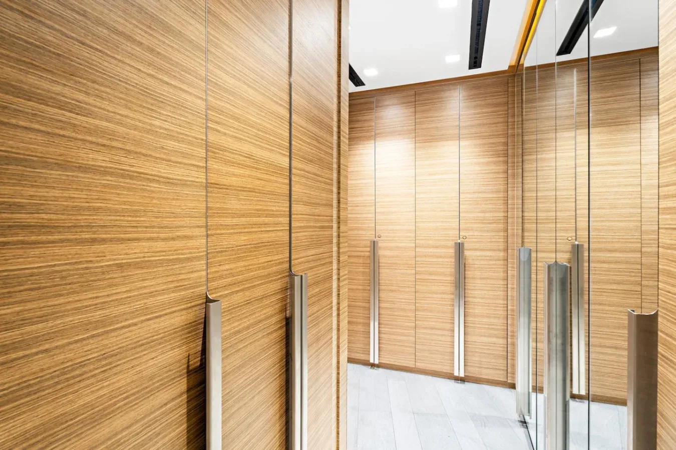 Entrada al ascensor: ¡Diseño de líneas depuradas con cálidos detalles de madera para una llegada con estilo!