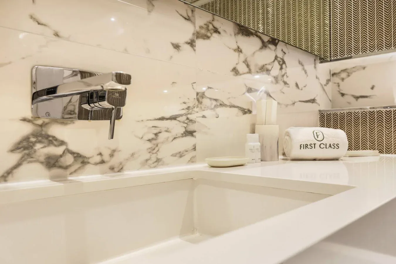 Un lavabo de baño con una amplia pila y un grifo montado en la pared.