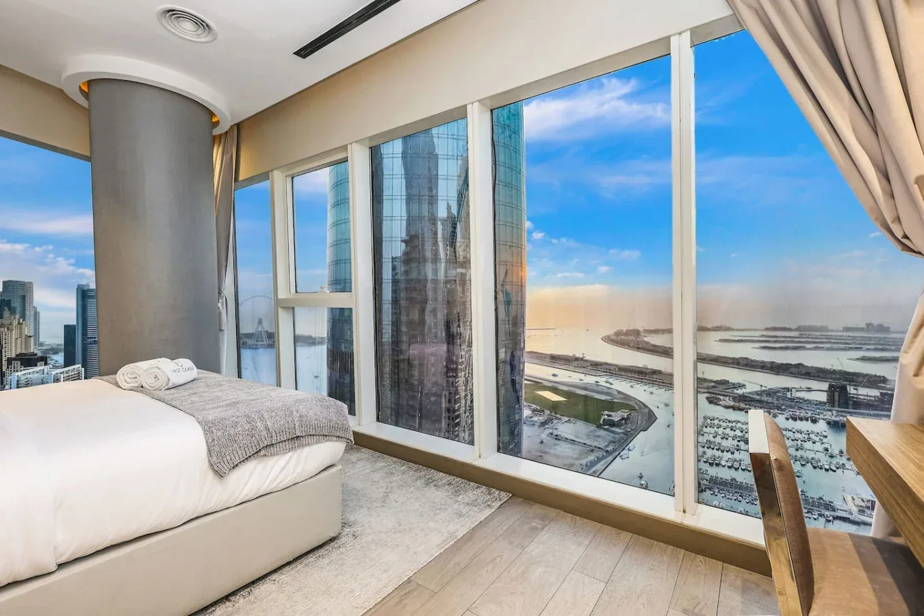 Un dormitorio con una cama junto a ventanales con vistas al agua.