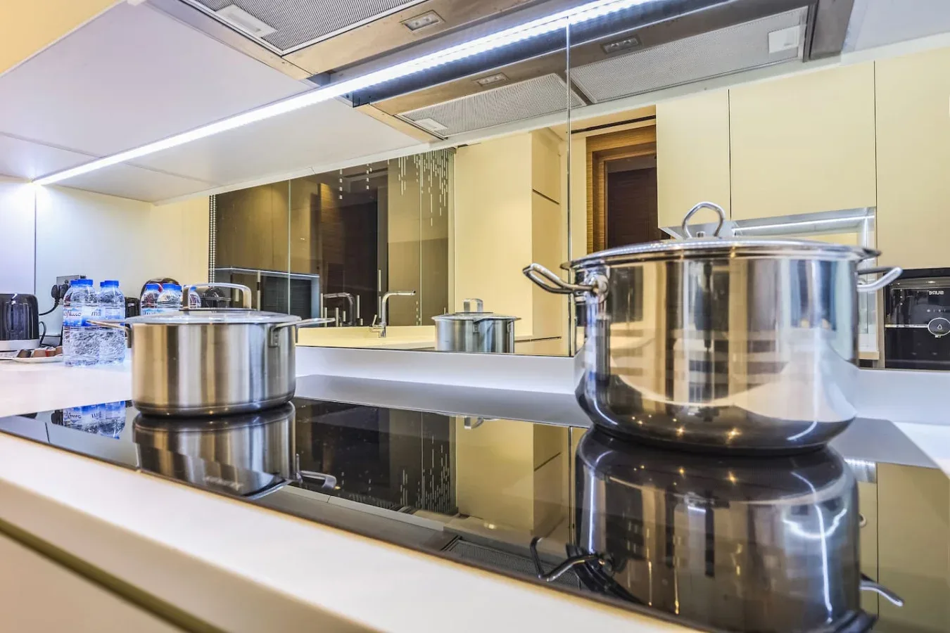 Una encimera de cocina moderna con ollas de acero inoxidable sobre la placa.